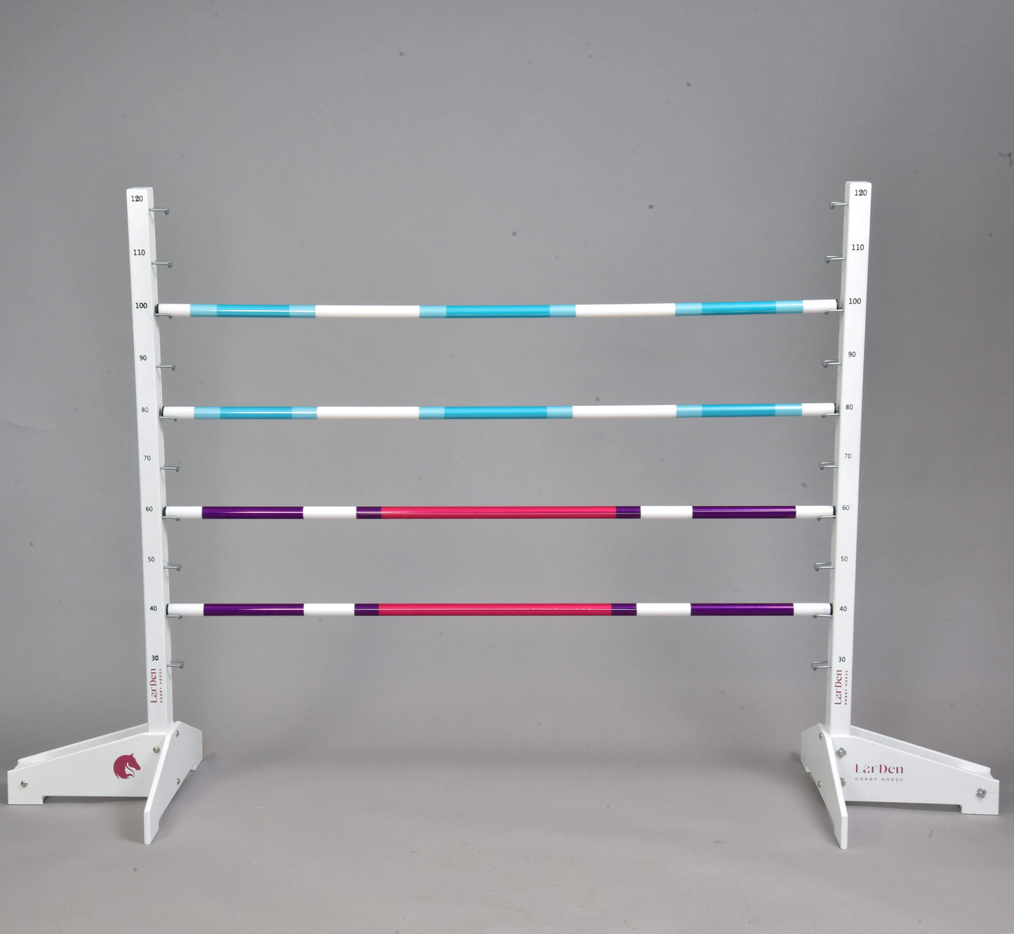 Obstacle 120 cm / 47 inch avec poteaux supplémentaires de Hobby Horse LarDen, avec cinq poteaux rayés bleus, blancs, violets et rouges, deux supports blancs réglables, adapté au Hobby Horsing en intérieur ou en extérieur. Fond gris uni.
