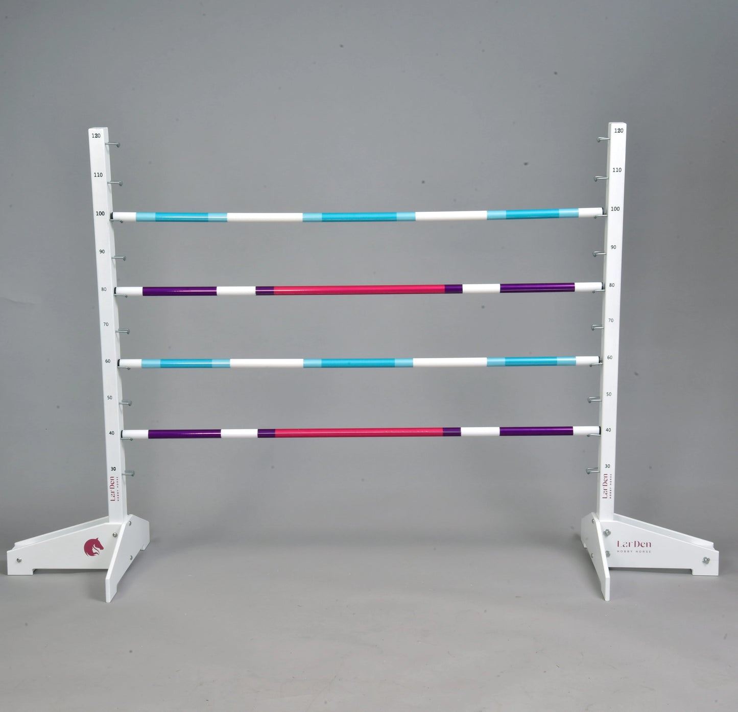 Obstacle 120 cm / 47 inch avec poteaux supplémentaires de Hobby Horse LarDen, avec quatre poteaux horizontaux blancs, turquoise, violets et rouges sur un support blanc réglable en hauteur, parfait pour le Hobby Horsing en intérieur ou en extérieur.