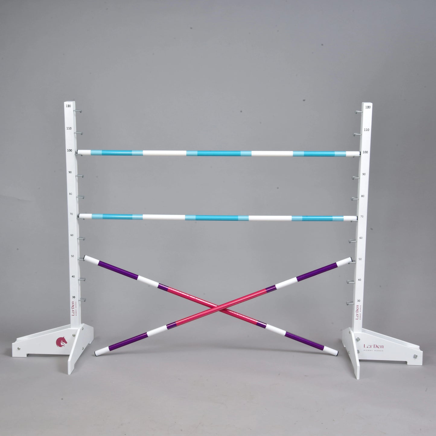 Obstacle 120 cm / 47 inch avec poteaux supplémentaires de Hobby Horse LarDen, comprenant deux chandeliers blancs, trois poteaux réglables bleus et blancs, deux poteaux croisés violets et blancs, idéal pour le Hobby Horsing en intérieur ou en extérieur. Présenté sur fond gris uni.
