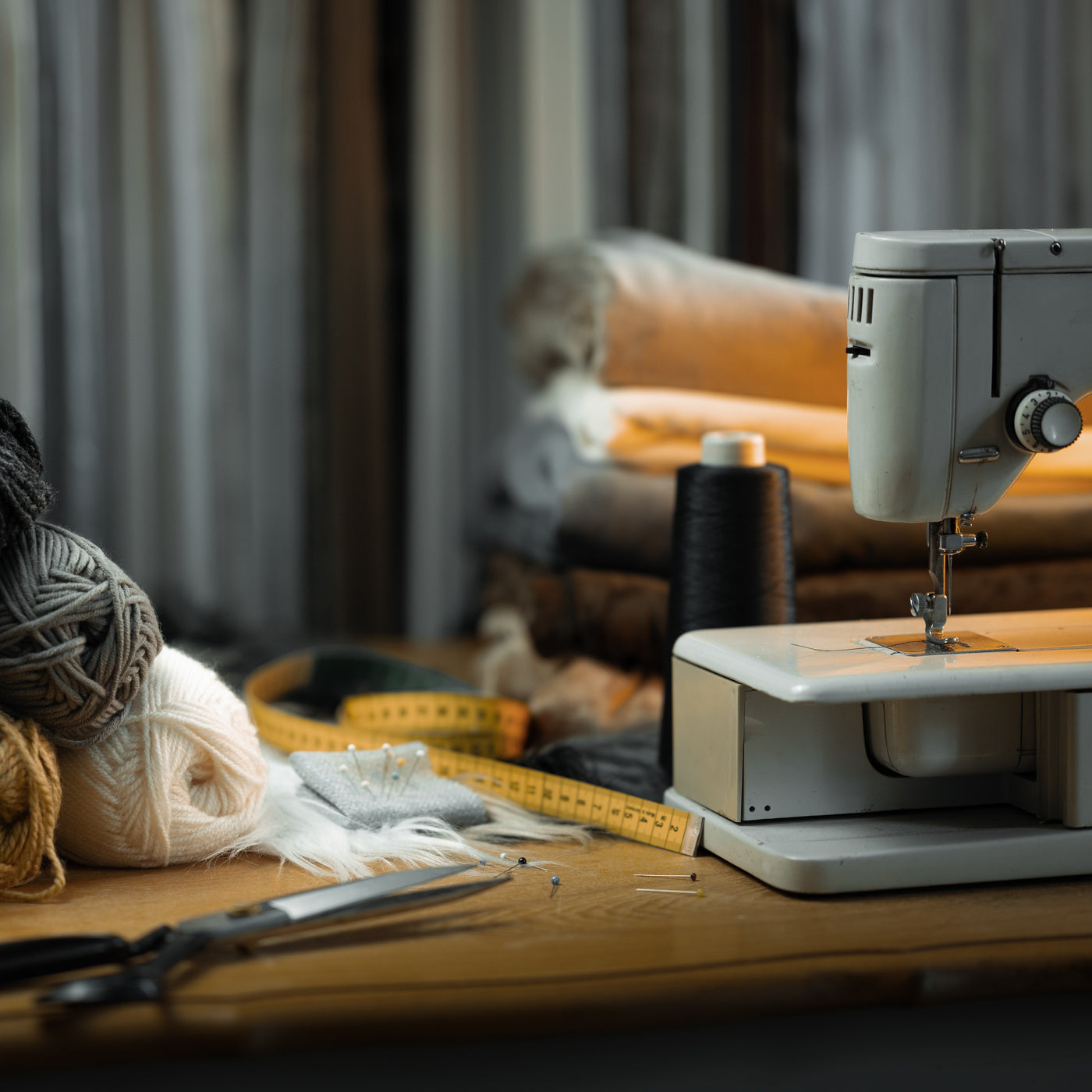 Eine Nähmaschine auf einem Holztisch mit Garn, Stoffrollen, Schere, Garnspulen und Stecknadeln in einem gemütlichen, gut beleuchteten Arbeitsbereich – perfekt zum Basteln einzigartiger Accessoires oder Kostüme für Hobby Horse.