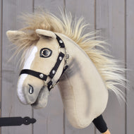 Hobby Horse Ivory Dream mit schwarzem Halfter – Größe XS von Hobby Horse LarDen in Größe XS, mit hellbraunem Fell, weißen Gesichtsabzeichen, flauschiger Mähne und schwarzem Halfter, vor hölzernem Hintergrund in der Hand einer Person.