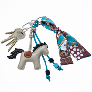 Schlüsselanhänger Horse Grey von Hobby Horse LarDen an einem Schlüsselring mit Schlüsseln, blauen Kordeln mit Perlen und einem bunt gemusterten Schal in Blau, Braun und Weiß, der am Schlüsselring befestigt ist.