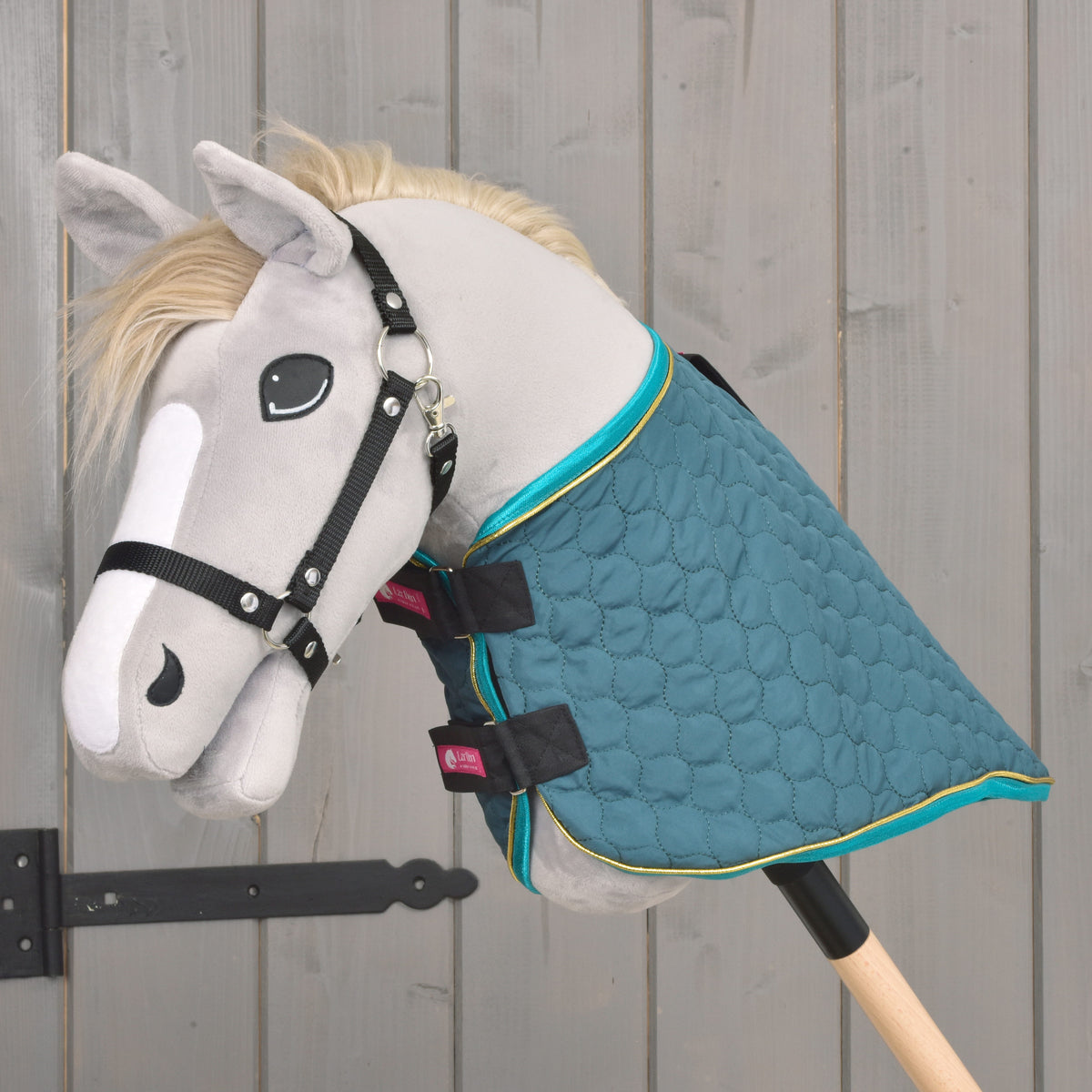Seitenansicht einer grünen gesteppten Hobby-Horse-Decke mit türkisfarbenem Besatz und abnehmbarem Halsteil