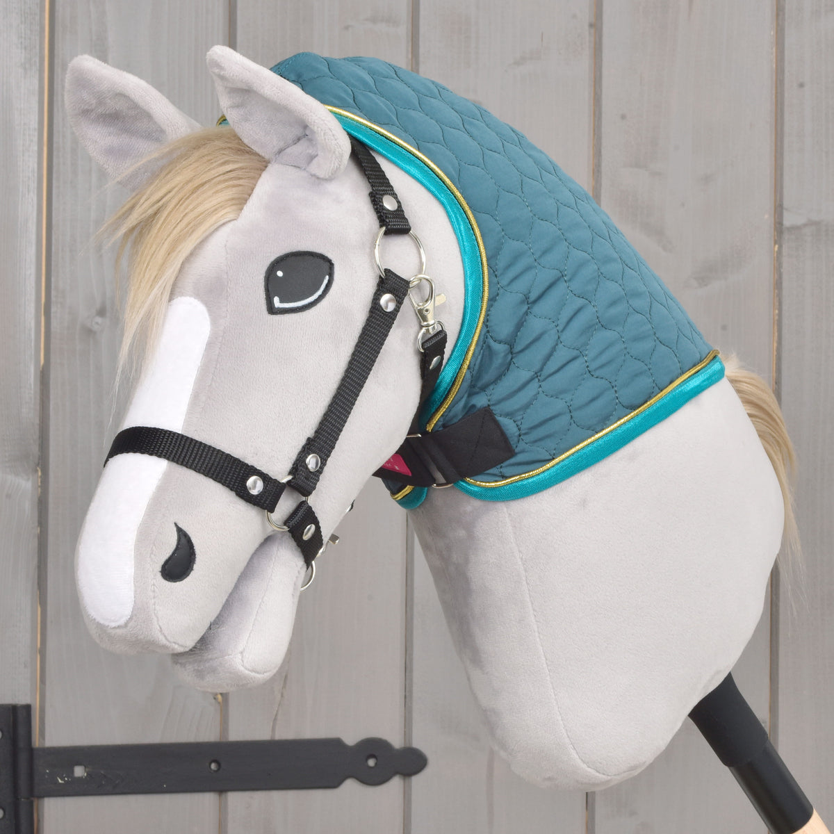 Grüne gesteppte Hobby-Horse-Decke mit abnehmbarem Halsteil von der Seite auf einem grauen Hobby Horse