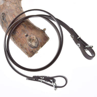 Hobby Horse LarDen Zügel - Light brown, um einen strukturierten Ast auf weißem Hintergrund gelegt, zeigen ihre stilvolle Lederoptik und Metallbeschläge, die an Zügel für gebisslose Zäumungen erinnern.