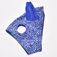 A patterned blue and white Horse Mask See by Hobby Horse LarDen, featuring a single eye hole and a pointed blue fabric accent on top, is displayed against a plain white background. This washable PES mask provides stylish and effective protection for your hobby horse.