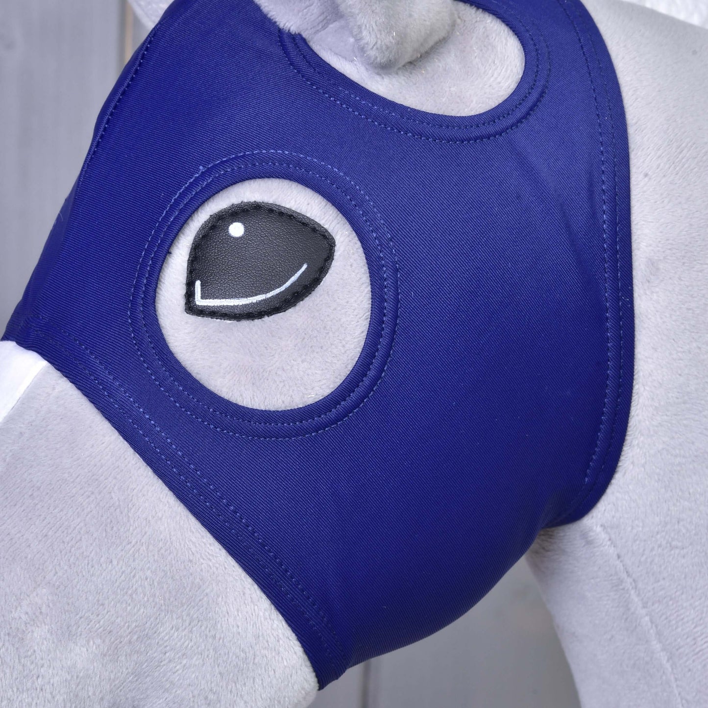Gros plan sur la tête d’un mannequin de cheval portant le Masque de cheval sans oreilles LarDen de Hobby Horse LarDen, un masque ajusté en Lycra bleu royal qui couvre le visage avec des ouvertures pour les yeux de style cartoon pour un look ludique.