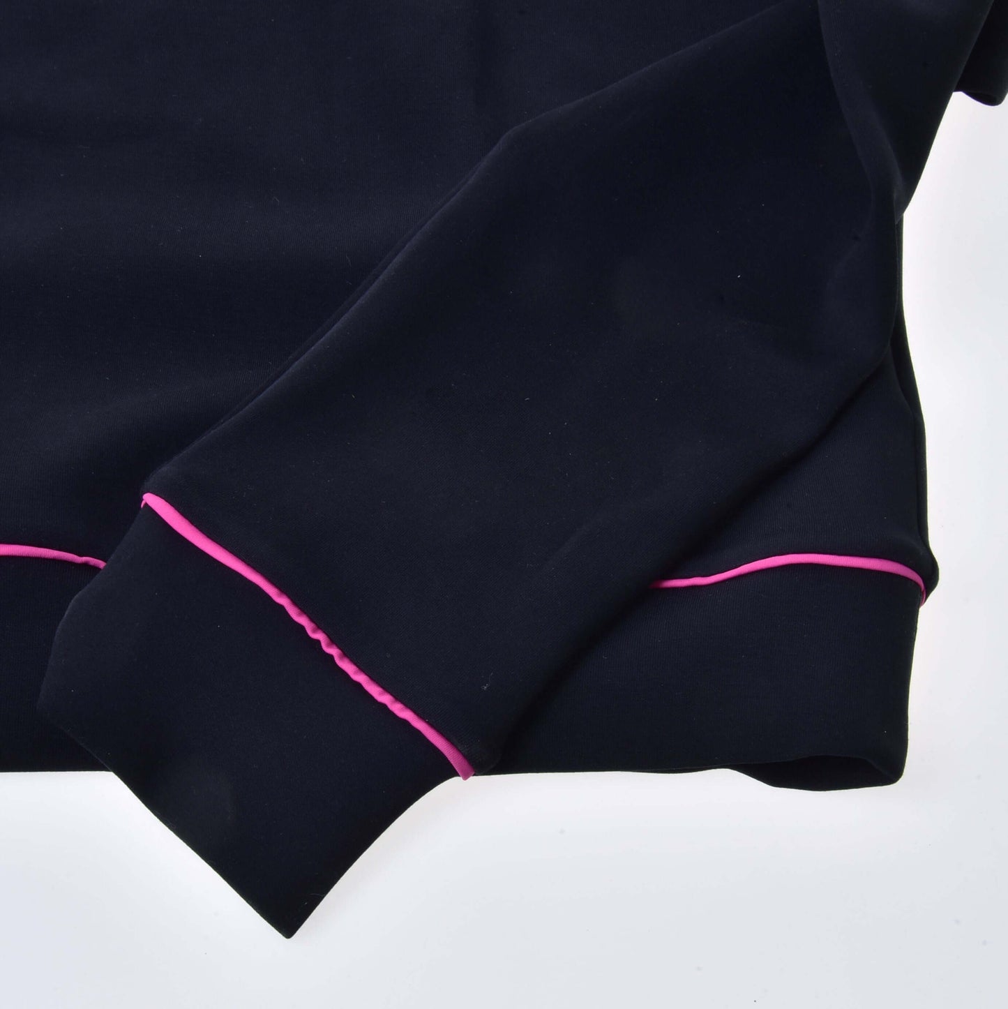 Gros plan de la manche et de l’ourlet d’un sweat-shirt LarDen noir de Hobby Horse LarDen montrant un liseré rose vif aux poignets et sur les bords, mis en valeur sur fond blanc.