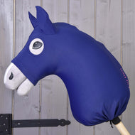 Hobby Horse Schutzanzug LarDen von Hobby Horse LarDen mit blauem Lycra-Kopf, weißen Ohren und weißer Schnauze sowie schwarzem comicartigem Auge auf einem Holzstab, vor einer grauen Holzwand.