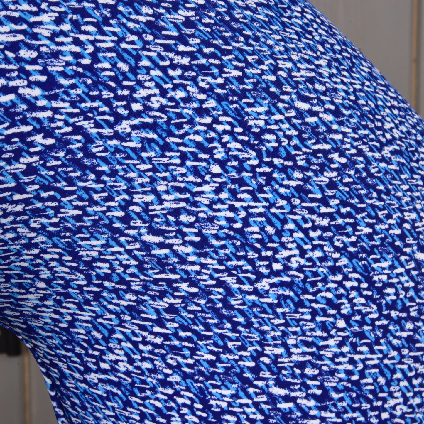Gros plan sur le tissu PES de la combinaison de protection See de Hobby Horse LarDen, montrant un motif abstrait bleu et blanc de petits traits et taches irréguliers pour un rendu dynamique et pixélisé.