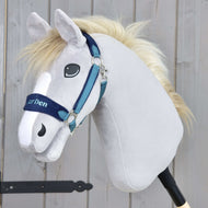 Das Hobby Horse LarDen mit dem Fellhalfter LarDen Blue hat einen hellgrauen Plüschkopf, eine weiße Mähne und ein blaues Fellhalfter und ist auf einem Stab vor Holz-Hintergrund.