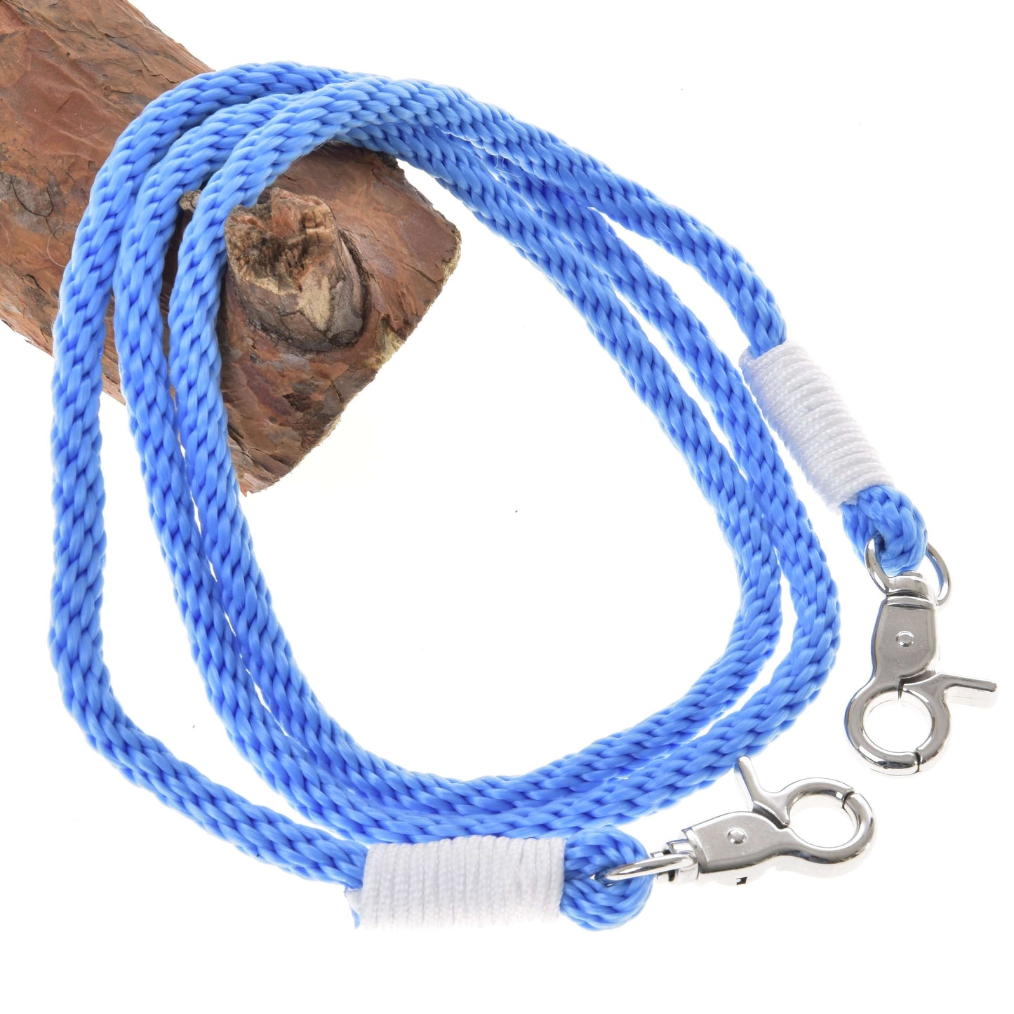 The Reins Sky by Hobby Horse LarDen is a coiled blue braided polypropylene rope with metal clips on each end, secured with white tape, shown on brown wood—ideal as handmade hobby horse reins.