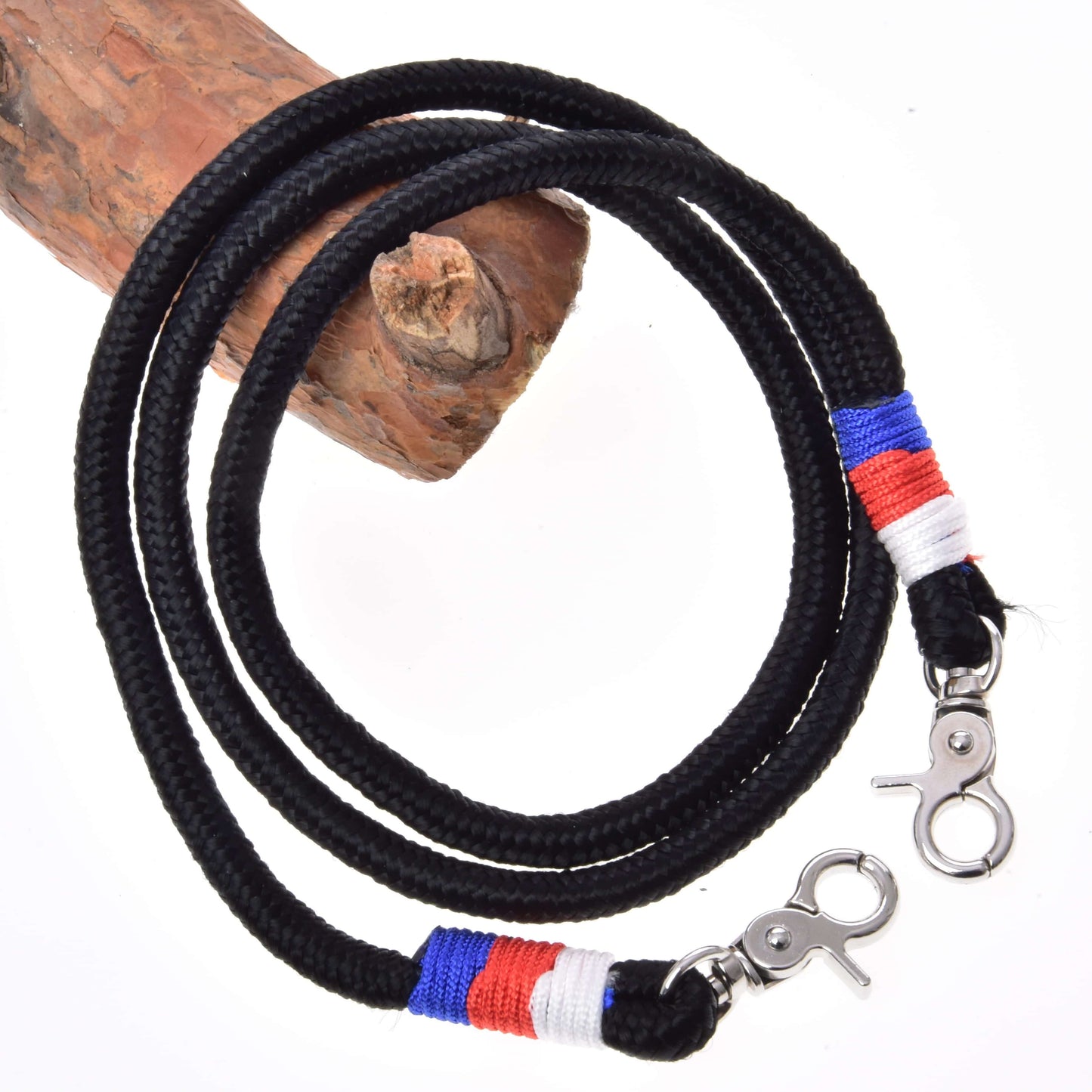Rênes Emblème CZ de Hobby Horse LarDen, lanière tressée noire en corde de polypropylène avec clips métalliques et accents de fil rouge, bleu et blanc près des clips, enroulée autour de bois sur fond blanc.