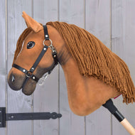 Hobby Horse Pippa mit Schwarzem Halfter von Hobby Horse LarDen mit kastanienbraunem Plüschkopf, langer Garnmähne und Holzstab – perfekt für fantasievolles Spielen vor jedem Zaun.