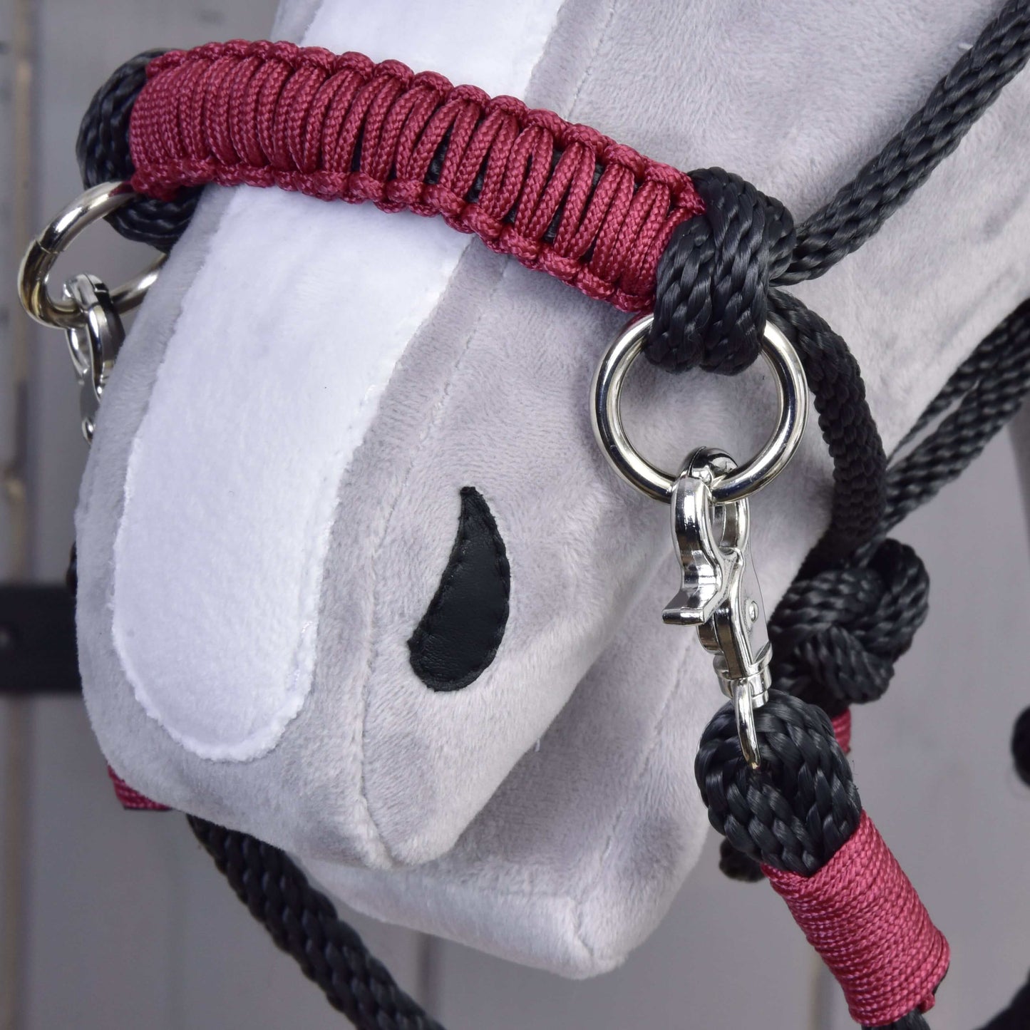 Nahaufnahme eines grauweißen Hobby Horse LarDen-Kopfes mit Seilset Maroon, mit schwarzem Seil, Metallringen, Karabinern und detaillierten Nähten im Stoff.