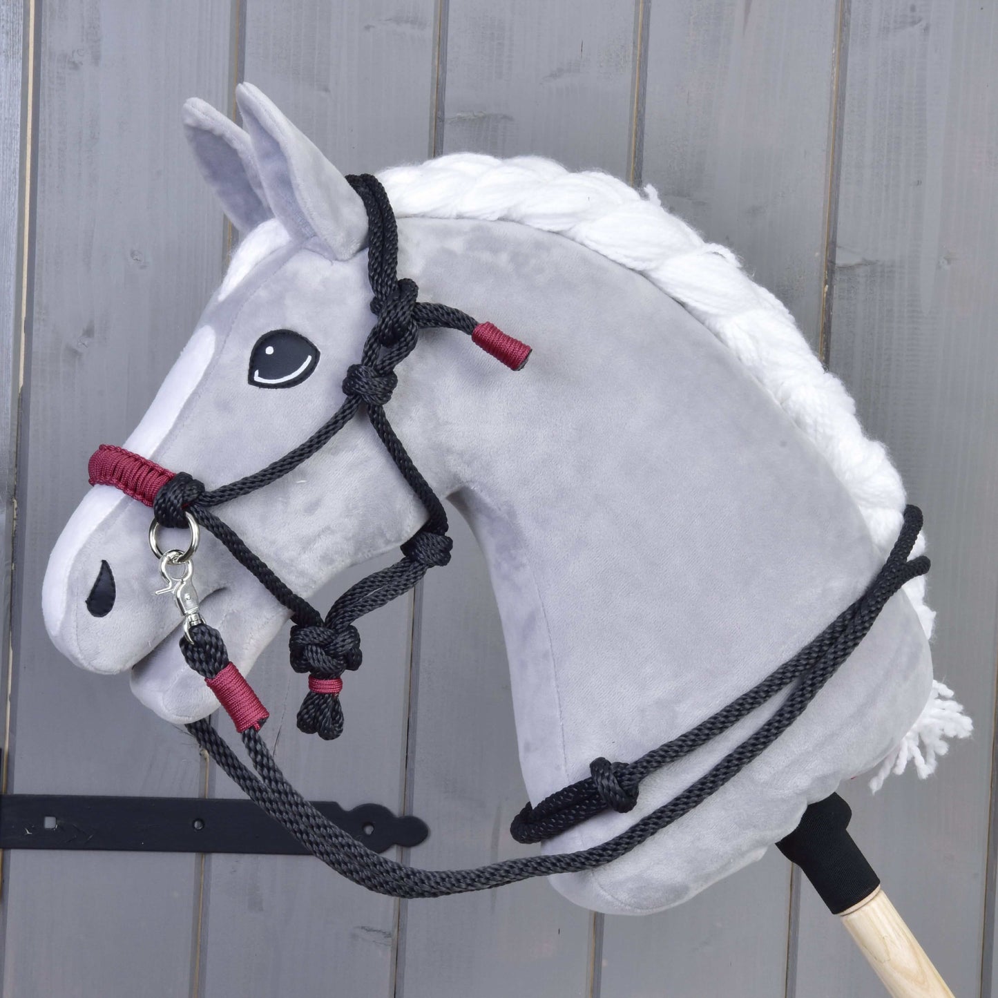 Seilset Maroon von Hobby Horse LarDen vor einer grauen Holzwand, mit bordeauxfarbenen Seilen für Hobby Horses.