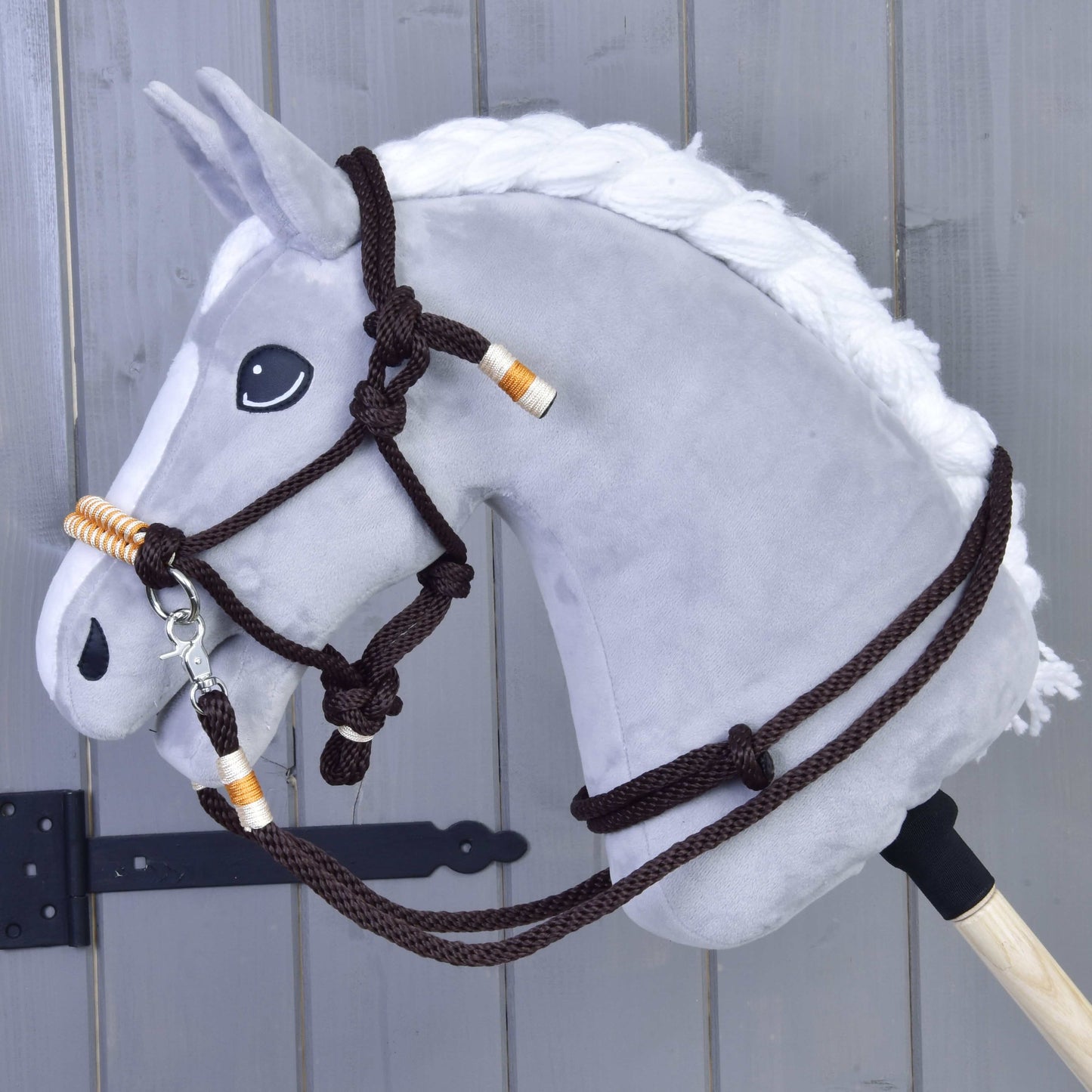 Hobby Horse LarDen Seilset Orange vor dem Hintergrund eines Holzzauns, mit einem orangefarbenen Seilset, das sicher an einem stabilen Holzstab befestigt ist.