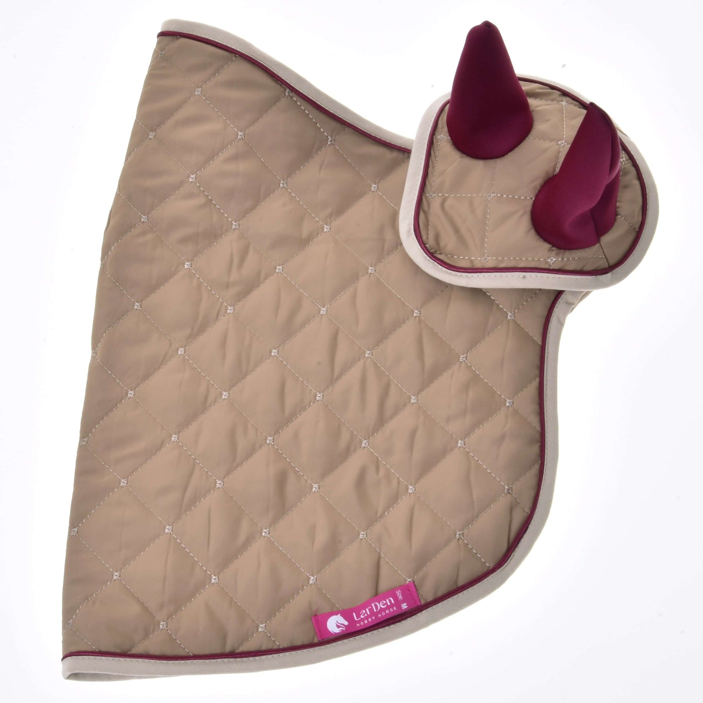 Set Roma von Hobby Horse LarDen ist ein Set aus gesteppter hellbrauner Schabracke und Fliegenhaube mit bordeauxfarbenen Ohren, beigefarbener Paspelierung und rosa Let’Den-Label – eine elegante Wahl für dein Pferd.