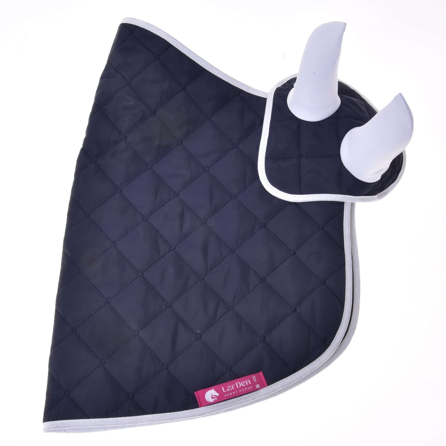 Set Monte von Hobby Horse LarDen ist eine dunkelblaue gesteppte Decke mit hellgrauer Einfassung und zwei weißen gepolsterten Ohrenschützern, die ein stilvolles Fliegenhauben-Set bilden. Ein pinkes Etikett mit Pferdelogo sorgt für zusätzliche Dekoration am Look deines Pferdes.