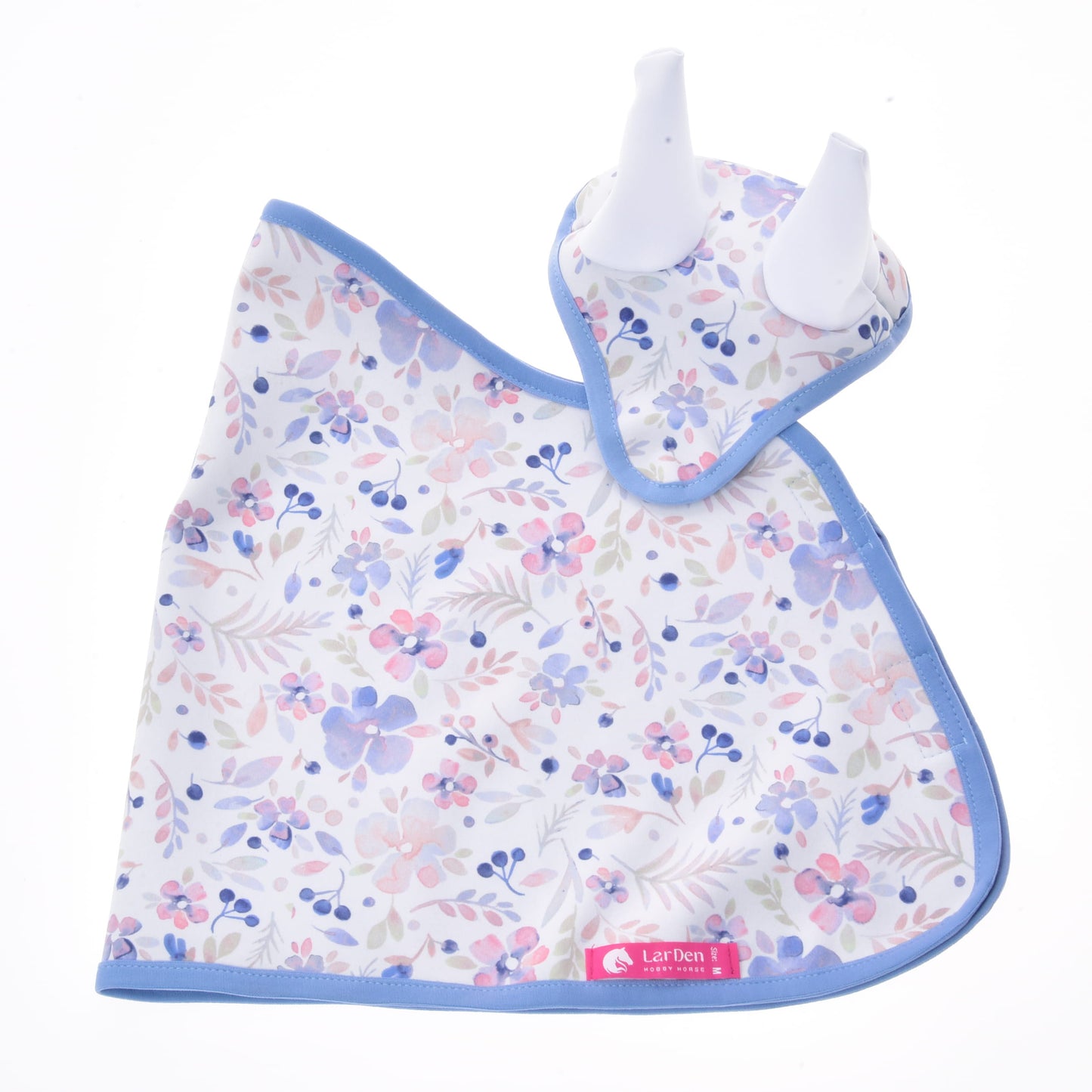 Set Vanessa NEW de Hobby Horse LarDen, comprenant un bavoir pour bébé et un anneau de dentition assorti à bordure bleue, tous deux avec un motif floral rose, violet et bleu sur fond blanc. L'anneau de dentition a deux embouts blancs en silicone en forme d'oreilles, ce qui en fait un charmant ensemble pour chambre de bébé.