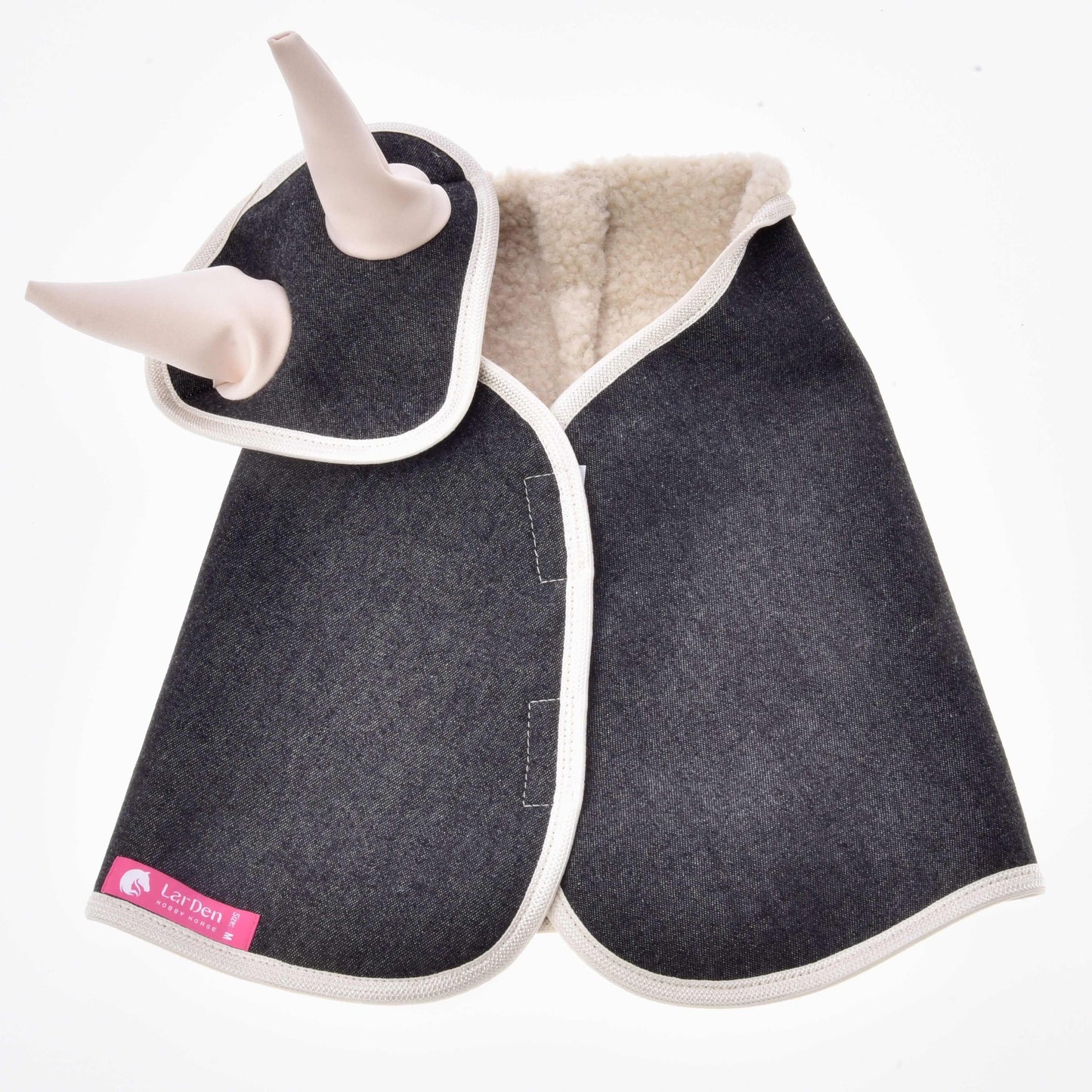 Die Hundejacke Set Blue Denim von Hobby Horse LarDen besteht aus blauem Denim mit weißer Borte, zwei Plüschhörnern nahe dem Hals für einen verspielten pferdeinspirierten Akzent, einem rosa Label in der Ecke und cremefarbenem Fleecefutter innen.