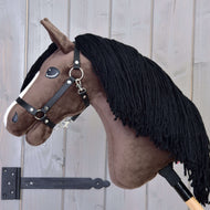 Hobby Horse Sisi mit Schwarzem Halfter von Hobby Horse LarDen mit weichem braunem Körper, weißem Streifen und schwarzer Garnmähne auf einem Holzstab – perfekt für Träume von einem Hannoveraner-Sportpferd oder einer Turnierstute.
