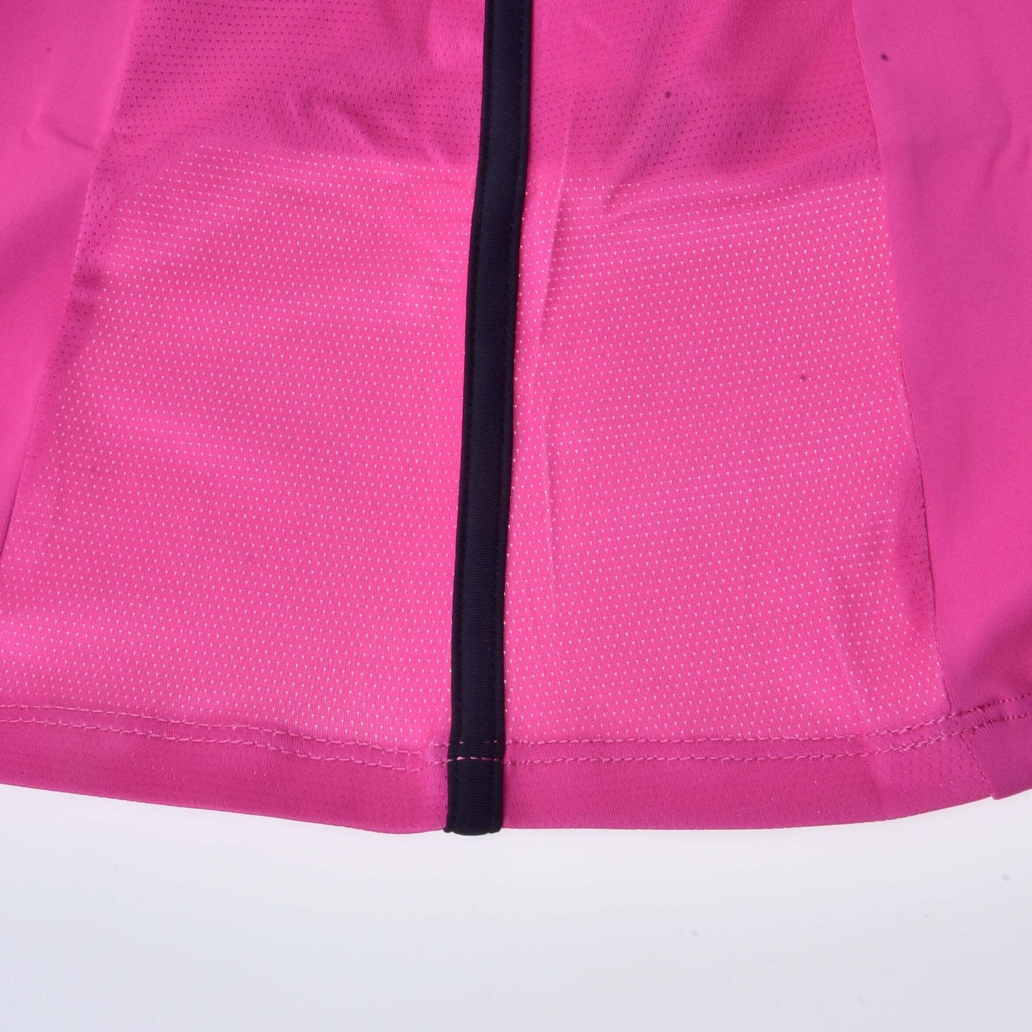 Nahaufnahme des unteren Bereichs des T-Shirt LarDen Pink von Hobby Horse LarDen aus Spandex mit einem mittig verlaufenden schwarzen Reißverschluss und kleinen weißen Punkten rechts neben dem Reißverschluss.