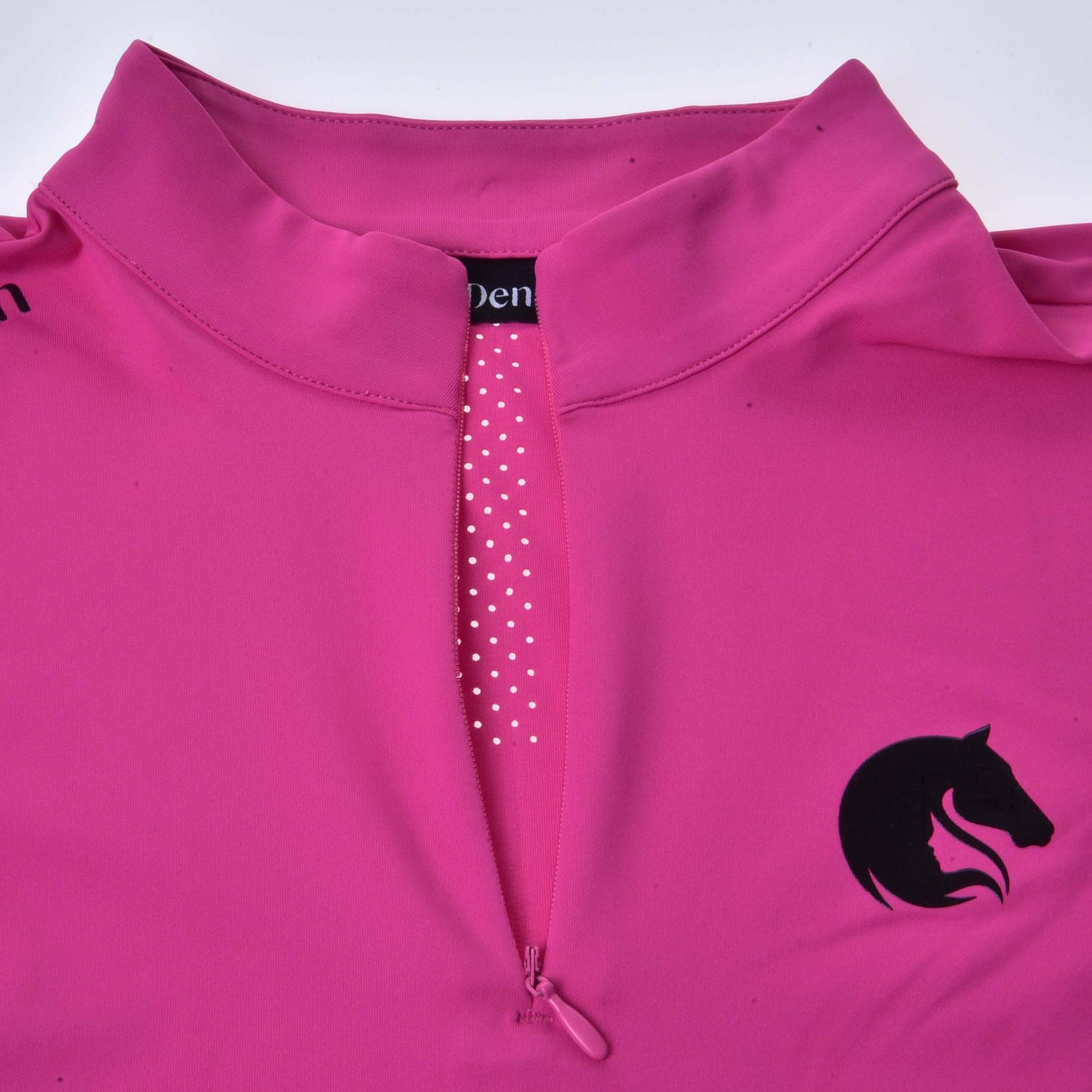 Das T-Shirt LarDen Pink von Hobby Horse LarDen ist ein leuchtend pinkes Sportshirt mit Kragen, kurzen Ärmeln, halblangem Reißverschluss vorn mit weiß gepunktetem Rand und einem schwarzen Pferdekopf-Logo auf der Brust.
