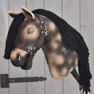 Hobby Horse Stormy avec licol noir de Hobby Horse LarDen, avec tête en peluche marron, crinière en fil noir, licol noir et yeux brillants en bouton, monté sur un bâton en bois sur fond en bois clair, une pièce enchanteresse inspirée de l'esprit d'un étalon hanovrien.