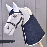 Set Thermo Blue von Hobby Horse LarDen zeigt einen Plüschkopf eines Hobby Horse mit weißen Ohren, einem Geschirr und einer gesteppten dunkelblauen Decke – ideal als charmanter Dekorationsakzent fürs Pferd.