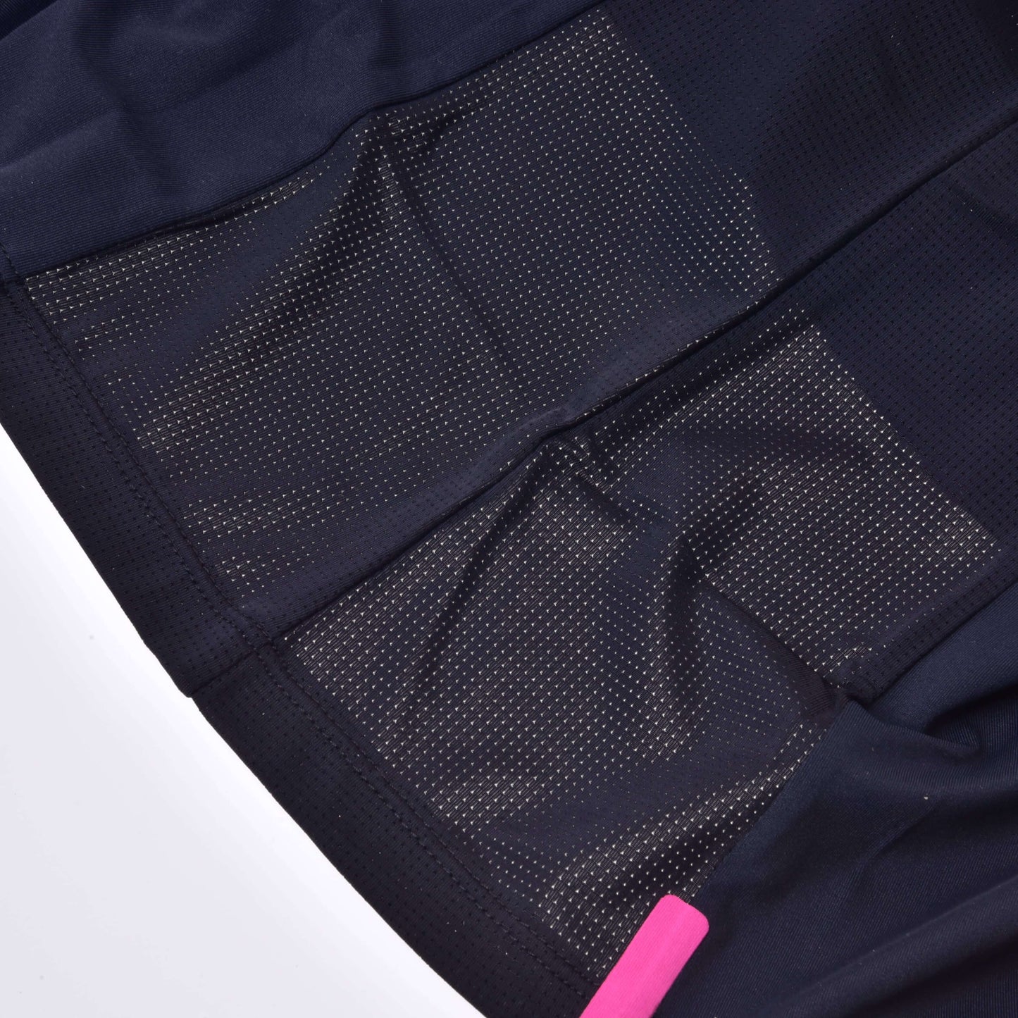 Nahaufnahme des T-Shirt LarDen Active Black von Hobby Horse LarDen mit schwarzem Spandex-Material, Mesh-Belüftungseinsätzen und Perforationen für Atmungsaktivität; ein rosa Etikett ist unten rechts teilweise sichtbar.