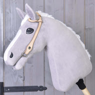 Westerntrense Einohr von Hobby Horse LarDen an einem grauen Plüschpferd auf Holzstab, mit hochwertiger Ledertrense vor einer Holzwand aus Brettern.