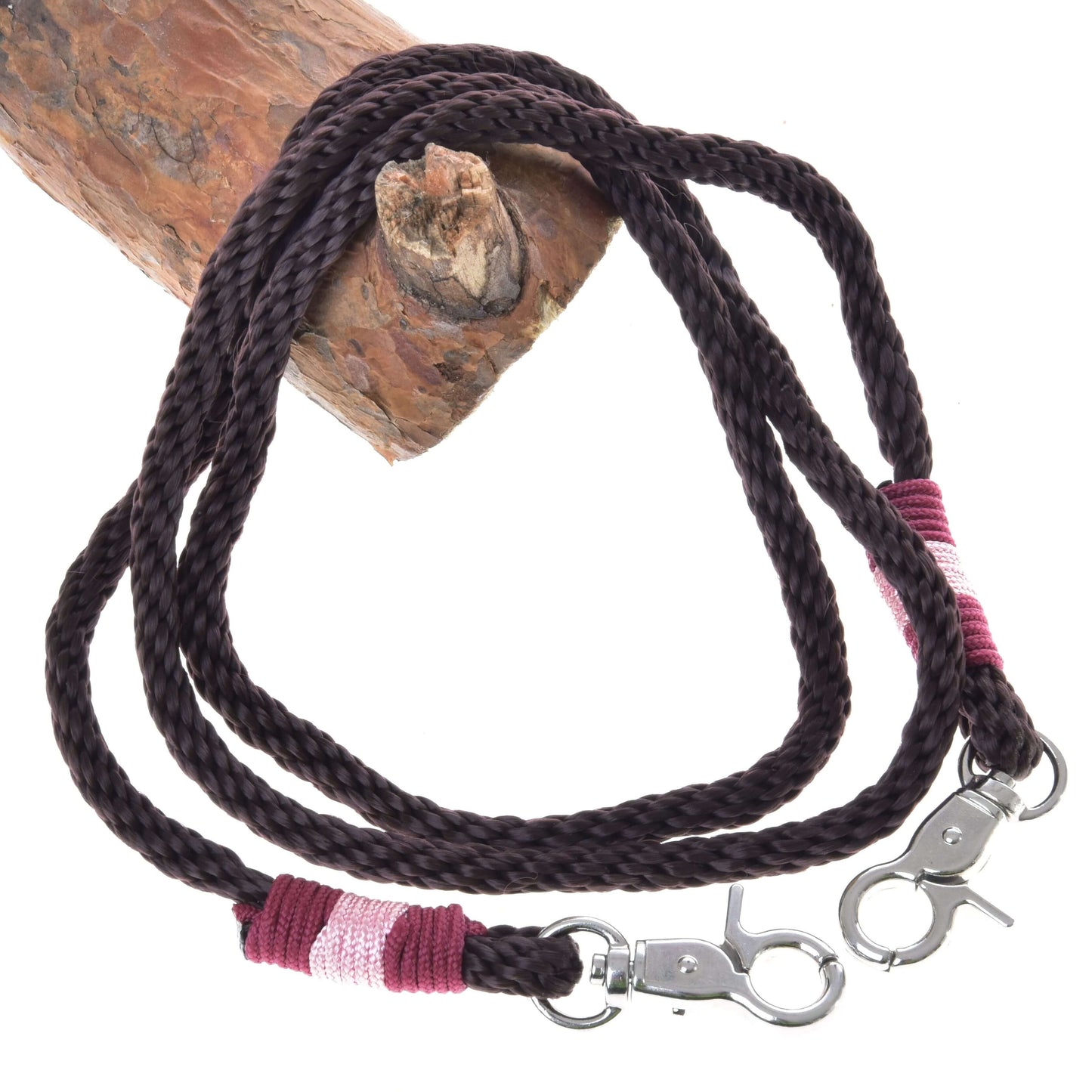 Zügel York von Hobby Horse LarDen, dunkelbraun geflochtene Zügel aus Polypropylen mit Metallclips sowie pinken und bordeauxroten Garnumwicklungen, aufgerollt auf Holz, ideal als handgefertigte Zügel für Hobby Horse