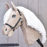 Hobby Horse Blondie mit Schwarzem Halfter von Hobby Horse LarDen mit beigem Gesicht, weißer Garnmähne und schwarzem Halfter auf einem Holzstab, vor einem hellgrauen Holz-Hintergrund.
