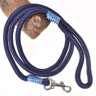 The Hobby Horse LarDen "Hobby Horse - rope stripe Blues" is a coiled dark blue rope leash with blue and white accents, featuring a silver metal clip and shown draped over wood on a white background.