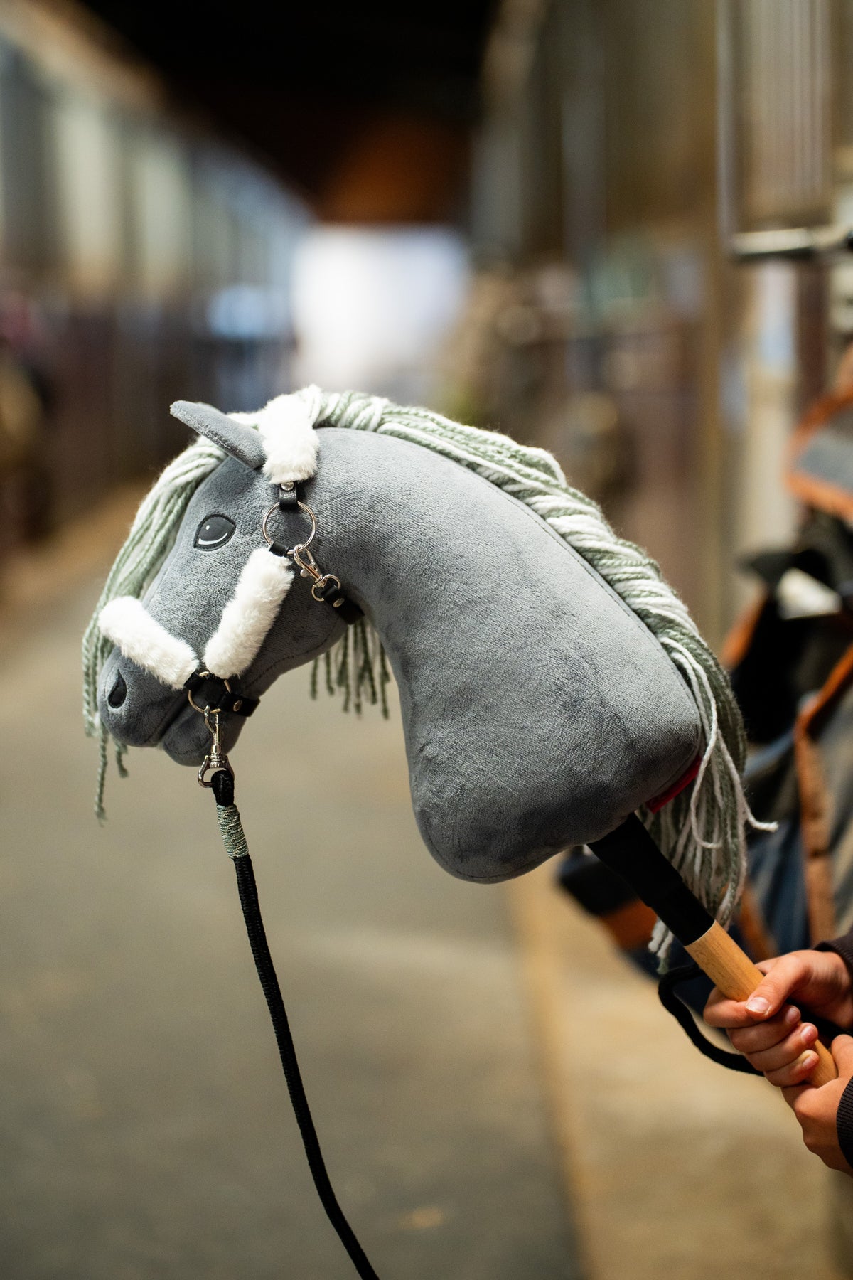 Hobby Horse Calypso mit schwarzem Halfter, mit grauem Plüschkopf, heller Garnmähne und schwarzem Führstrick