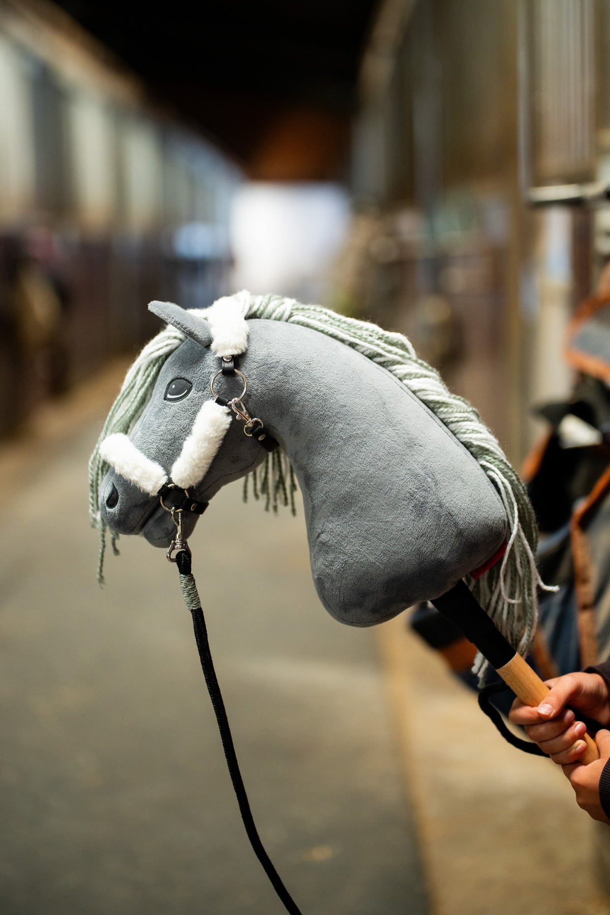 Hobby-Horse-Halfter mit Fell Teddy Classic an einem grauen Plüschkopf mit weißem Fellbesatz und schwarzem Führstrick