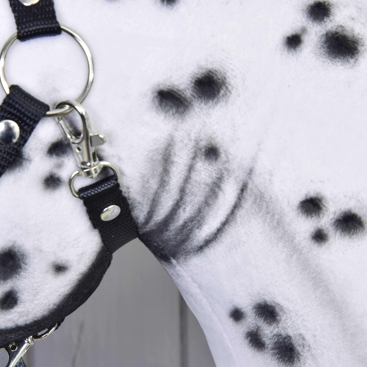 Gros plan sur Hobby Horse Chantal de LarDen, avec encolure blanche à pois noirs et licol noir avec anneaux et boucles argentés. Le motif de fourrure unique fabriqué à la main met en valeur cette jument.