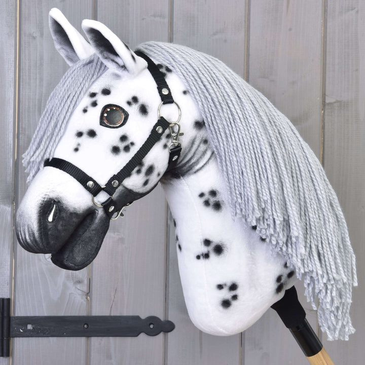 Hobby Horse Chantal mit schwarzem Halfter von LarDen, weißer Plüschkopf mit schwarzen Flecken und langer grauer Garnmähne