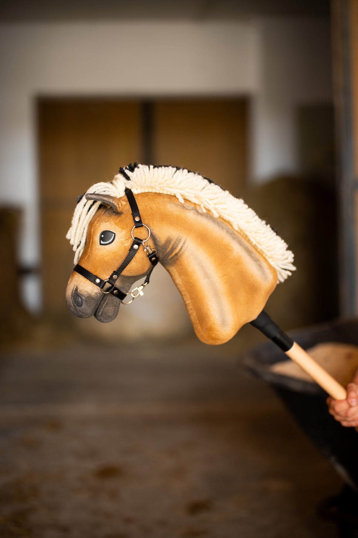 Hobby Horse Colby mit schwarzem Halfter im Profil, mit cremefarbener Garnmähne und silbernen Halfterbeschlägen