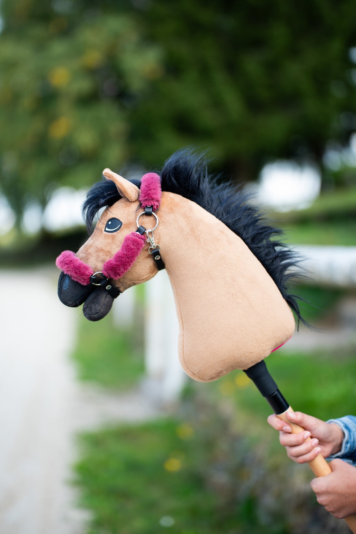 Hobby-Horse-Halfter mit Fell Teddy Maroon an einem sandfarbenen Hobby Horse mit schwarzer Mähne, im Freien gehalten