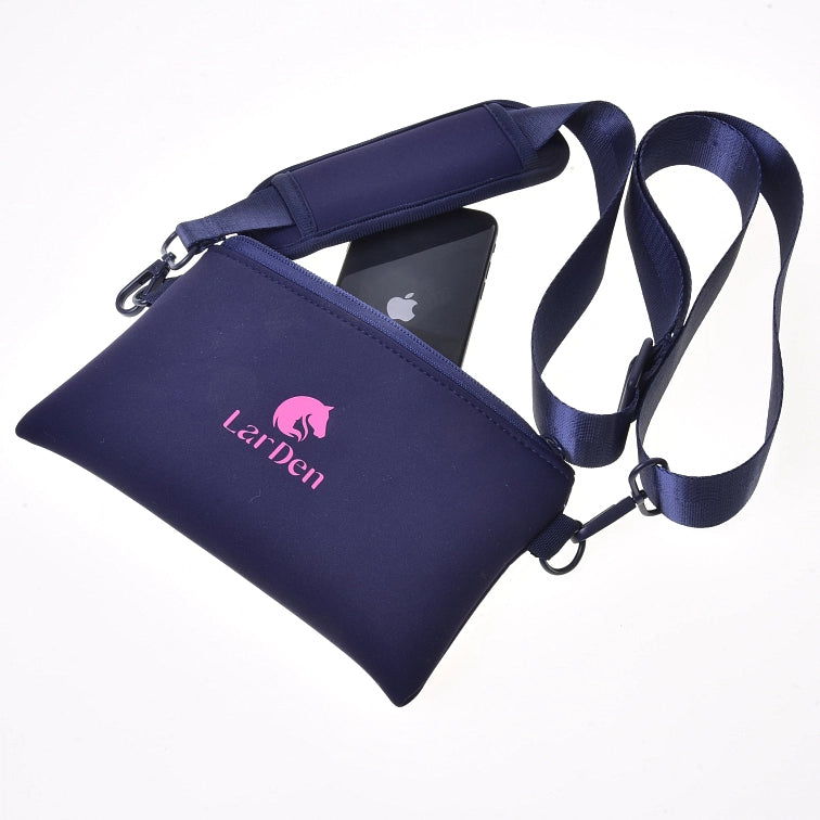 Sac bandoulière LarDen bleu marine avec logo rose, présenté avec une bandoulière réglable et un smartphone noir partiellement glissé dans la poche zippée, idéal pour transporter l'essentiel à votre prochain événement de Hobby Horsing, sur fond blanc.
