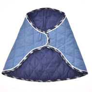 Die Decke Beautiful Jeans von Hobby Horse LarDen ist ein gesteppter blauer und marineblauer Mantel mit weißem Rand und kariertem Besatz, mit geschwungenem, überlappendem Design und Rautensteppung, flach liegend vor weißem Hintergrund.