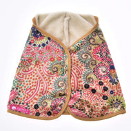 The Blanket Jungle by Hobby Horse LarDen is a vibrant patterned cape with a soft cream lining, tan trim, and pink, green, blue, and orange floral and dot designs. A pink LarDen label appears on the lower left corner.