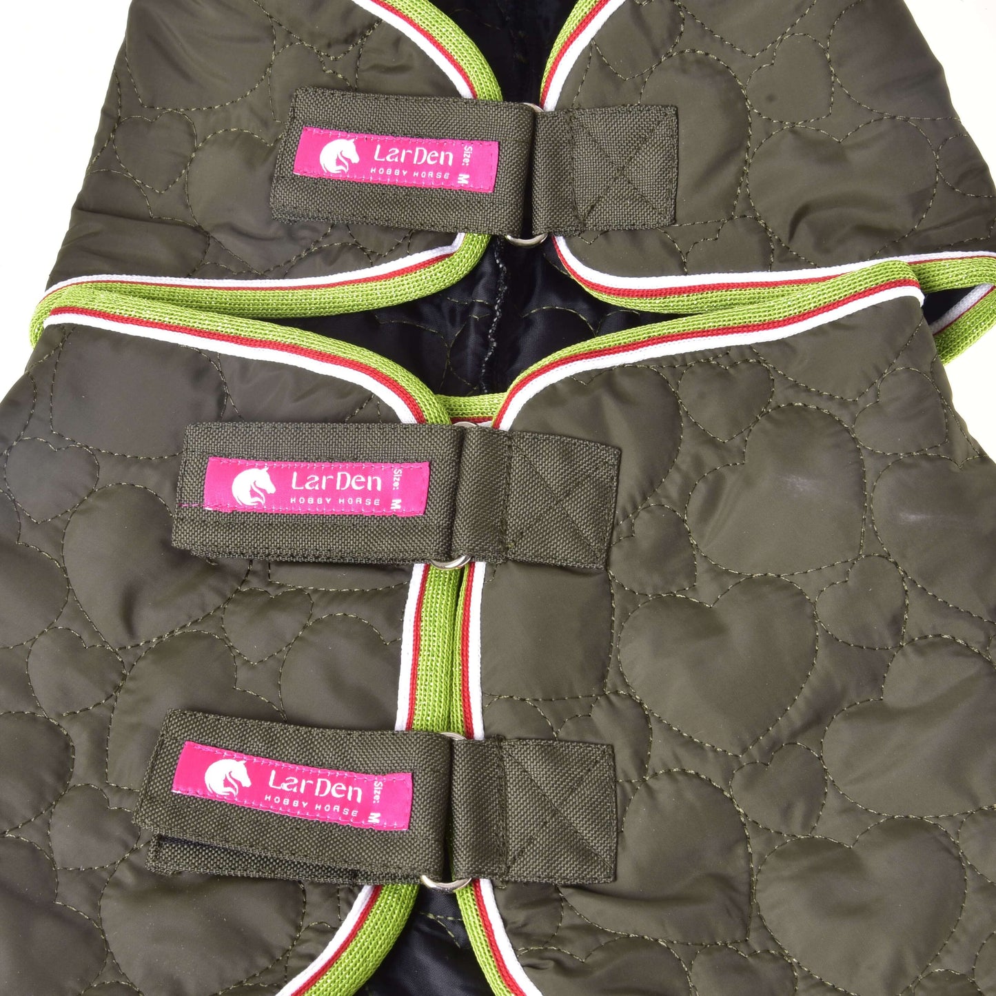 Nahaufnahme der Decke mit abnehmbarem Halsteil Rubby von Hobby Horse LarDen, ein dunkles gestepptes Design mit grünem, weißem und rotem Besatz, befestigt mit drei Klettverschlüssen. Jeder Verschluss zeigt ein rosa Etikett mit weißem Pferdelogo und „LerDen Lucky Stone“.