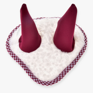 Ohrenkappe Cube Red von Hobby Horse LarDen ist ein weißes, herzförmiges Plüschteil mit rotem Vichykaro-Besatz und zwei hohen bordeauxroten Kegeln, das an eine verspielte Ohrenkappe für Hobby Horse erinnert.