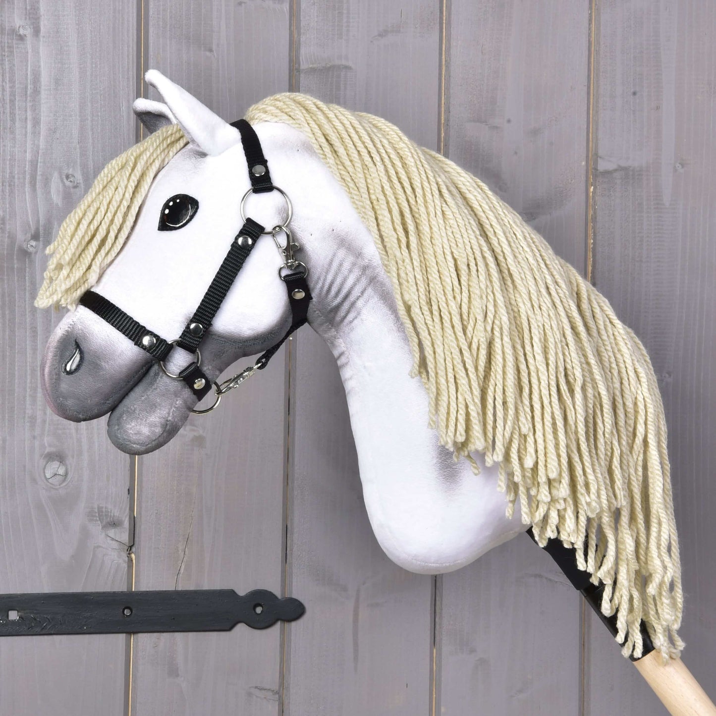 Hobby Horse Little Lady mit Schwarzem Halfter von Hobby Horse LarDen mit weißem Plüschkopf, dicker blonder Garnmähne und schwarzem Halfter auf einem Holzstock – perfekt für fantasievolles Spiel oder Dressurtraining.