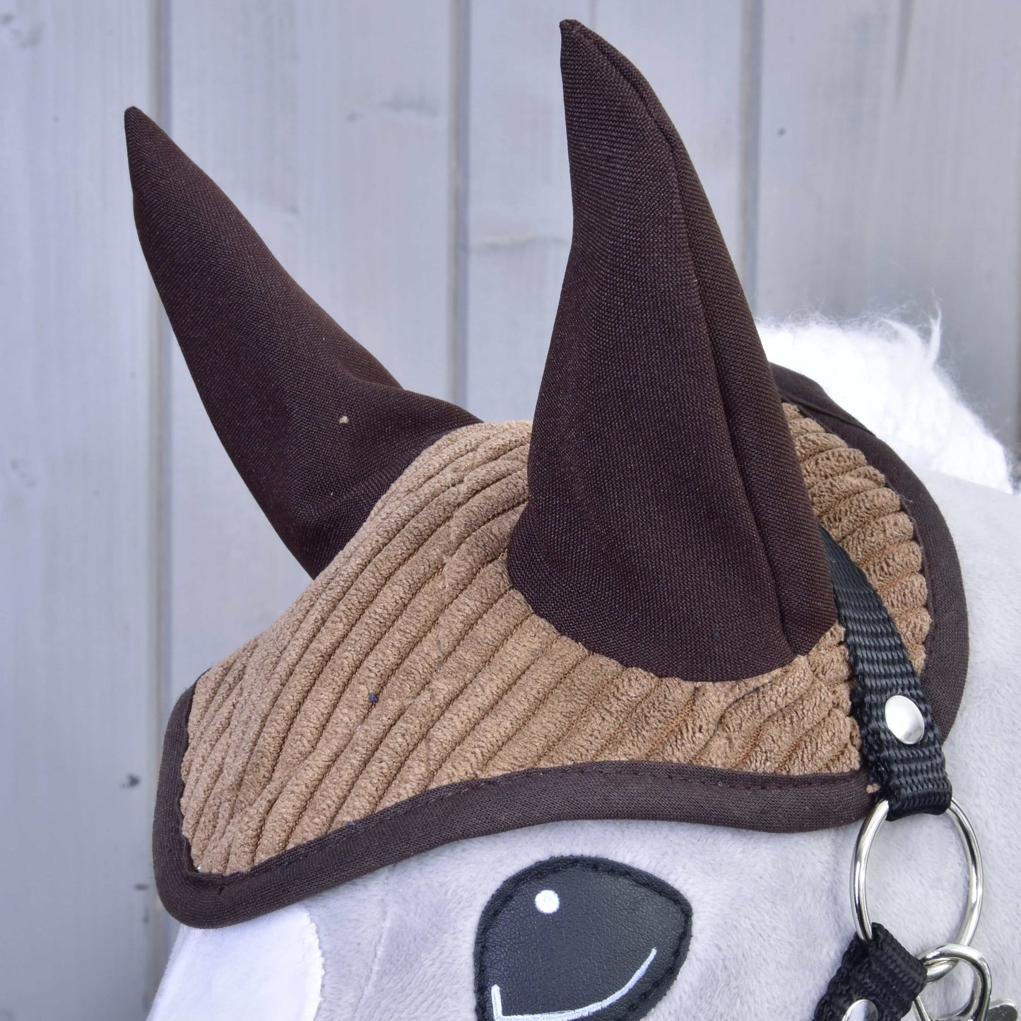 Nahaufnahme des Hobby Horse LarDen Set Manchester Le Chocolate Plüschspielzeugs mit brauner gerippter Fliegenhaube, dunkelbraunen Ohren, weißem Gesicht, schwarzem Zaumzeug und schlicht gesticktem Auge – ideal als charmante Pferdedekoration.