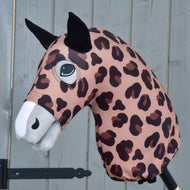 Hobby Horse LarDen „Hobby Horse Schutzanzug Glamour (Lycra)“ mit rosa-braunem Leopardenmuster aus Lycra, schwarzen Ohren und weißer Schnauze, auf einem Stab vor grauem Holz-Hintergrund.