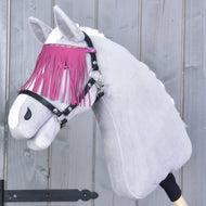 The Hobby Horse LarDen plush hobby horse wears the Halter black with pink fringes and stands against a gray wooden background, featuring a white coat and stylish pink-fringed browband.